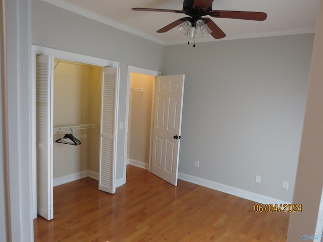 unfurnished bedroom with hardwood / wood-style floors, ornamental molding, a closet, and ceiling fan