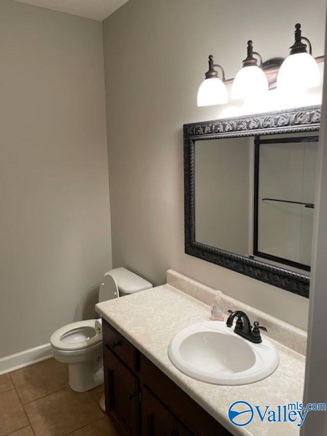 bathroom featuring vanity, tile patterned floors, and toilet