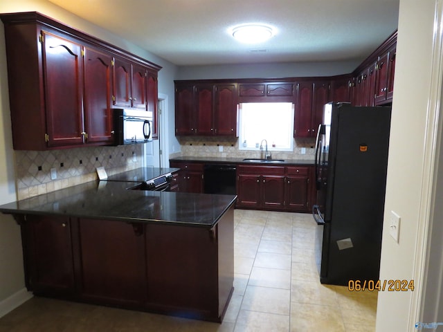 kitchen featuring tasteful backsplash, sink, black appliances, and kitchen peninsula