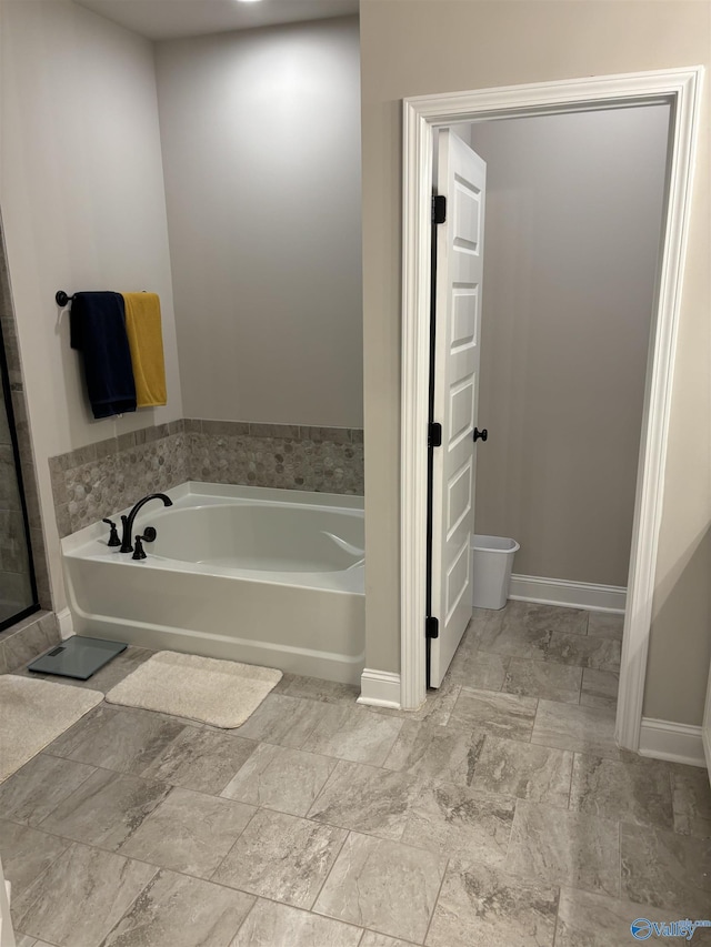 12794 Hudbug Dr, Madison, AL 35756 - bathroom featuring a bath and baseboards