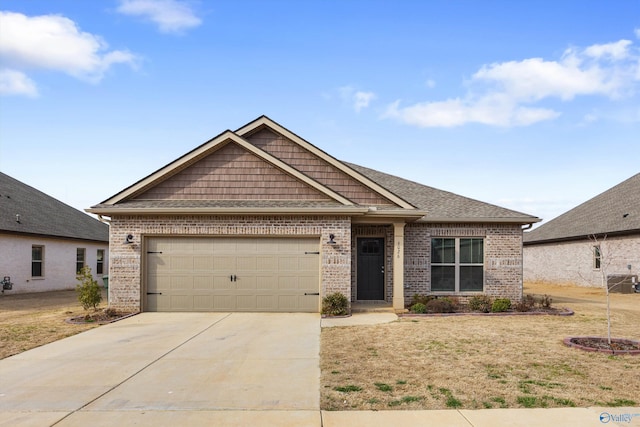 craftsman house with a garage, a front yard, concrete driveway, and brick siding