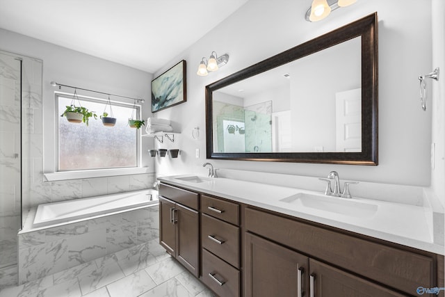 bathroom featuring a garden tub, marble finish floor, a sink, and a marble finish shower