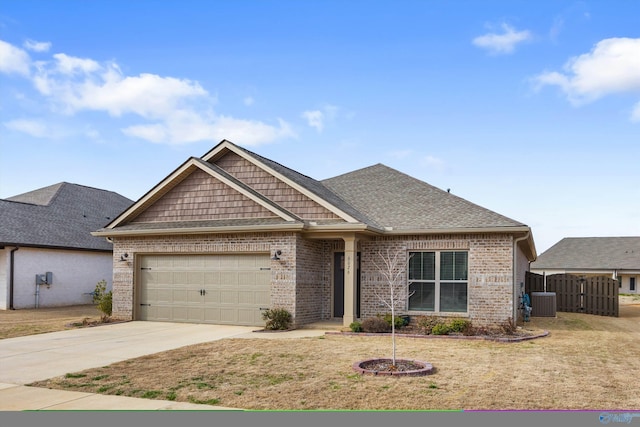 craftsman-style home featuring an attached garage, central AC, brick siding, driveway, and roof with shingles