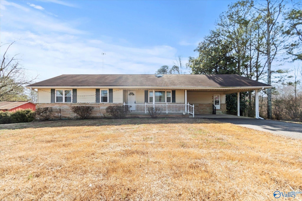 ranch-style house featuring a front lawn, a carport, and covered porch