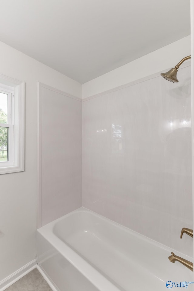 bathroom featuring shower / bath combination and baseboards