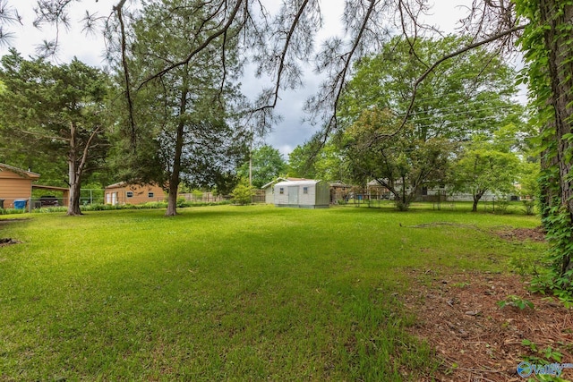 view of yard with an outbuilding, a storage shed, and a fenced backyard