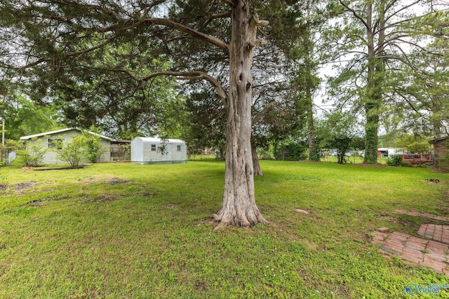 view of yard featuring an outbuilding, a storage shed, and fence