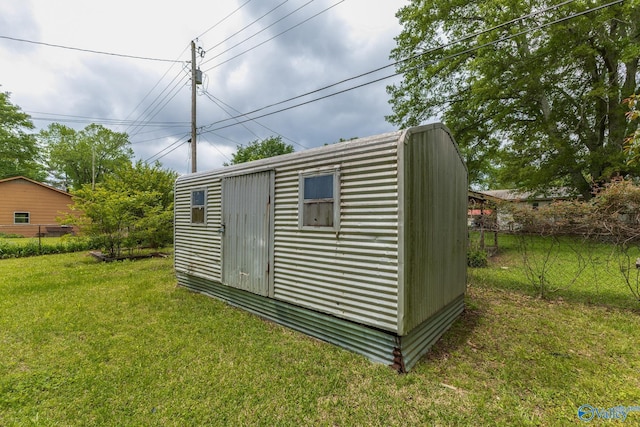 view of outbuilding featuring fence and an outbuilding