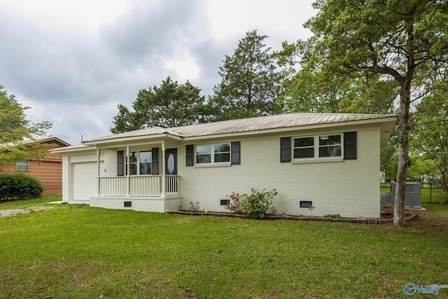 ranch-style house featuring metal roof, a front yard, crawl space, brick siding, and a garage