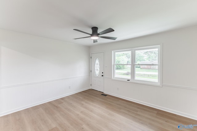 entryway with visible vents, a wainscoted wall, a ceiling fan, and light wood finished floors