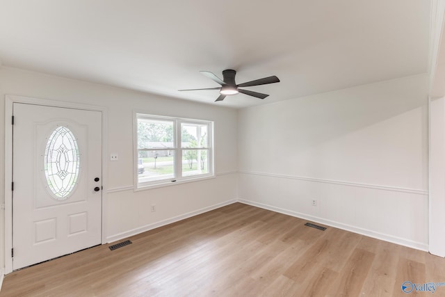 foyer entrance featuring baseboards, visible vents, ceiling fan, and light wood-style floors
