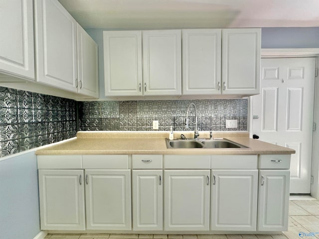 kitchen with sink, tasteful backsplash, and white cabinetry