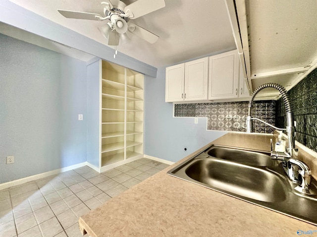 kitchen with white cabinets, ceiling fan, light tile patterned floors, and sink