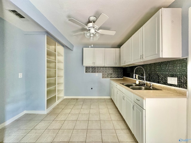 kitchen featuring ceiling fan, white cabinets, light tile patterned floors, sink, and decorative backsplash