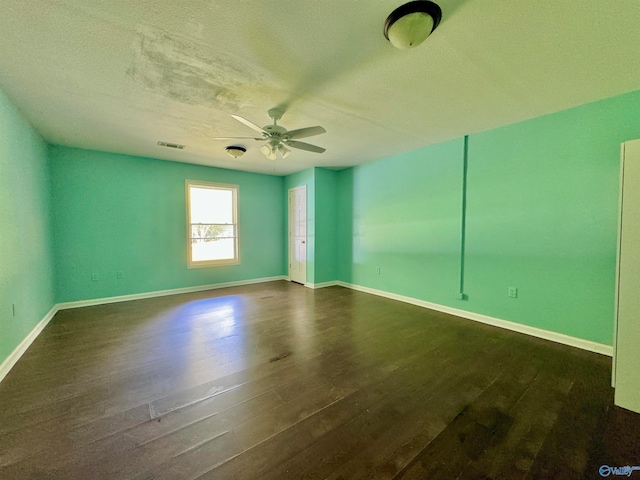 spare room featuring a textured ceiling, ceiling fan, and dark wood-type flooring