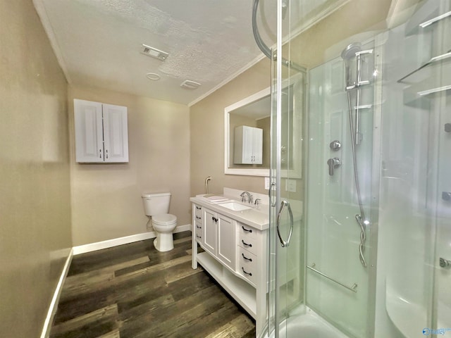 bathroom featuring hardwood / wood-style flooring, walk in shower, ornamental molding, vanity, and toilet