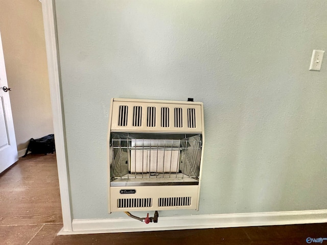 room details featuring heating unit and hardwood / wood-style flooring