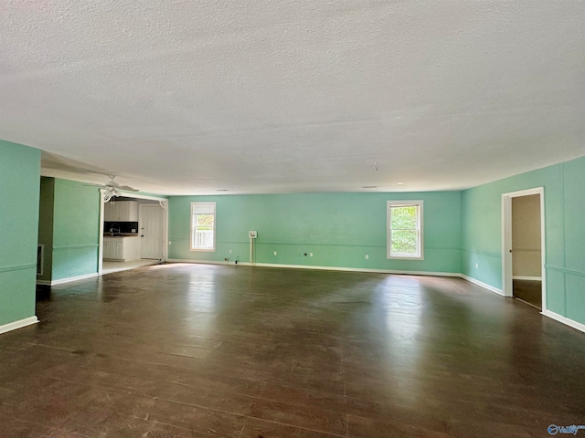 empty room featuring a textured ceiling, dark hardwood / wood-style flooring, and ceiling fan