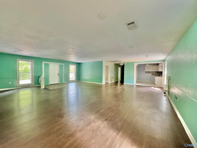 unfurnished living room with ceiling fan and hardwood / wood-style floors