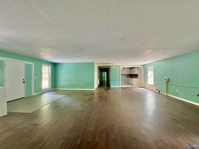 unfurnished living room with a textured ceiling and wood-type flooring