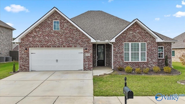 view of front of home featuring cooling unit, a front yard, and a garage