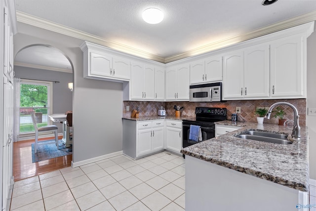 kitchen featuring stainless steel microwave, stone counters, a sink, crown molding, and black electric range oven