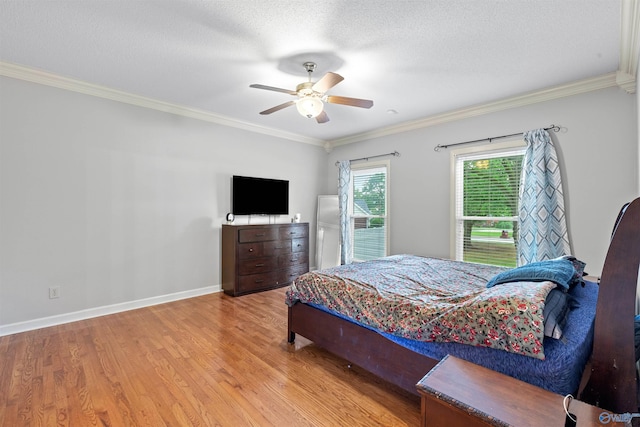 bedroom with wood finished floors, a ceiling fan, a textured ceiling, and crown molding