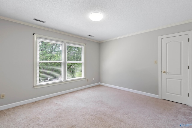 empty room featuring crown molding, a textured ceiling, visible vents, and light carpet