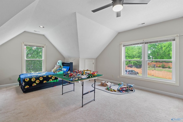 playroom with ceiling fan, visible vents, vaulted ceiling, baseboards, and carpet floors