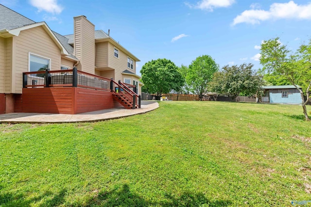 view of yard featuring a wooden deck, stairway, and fence