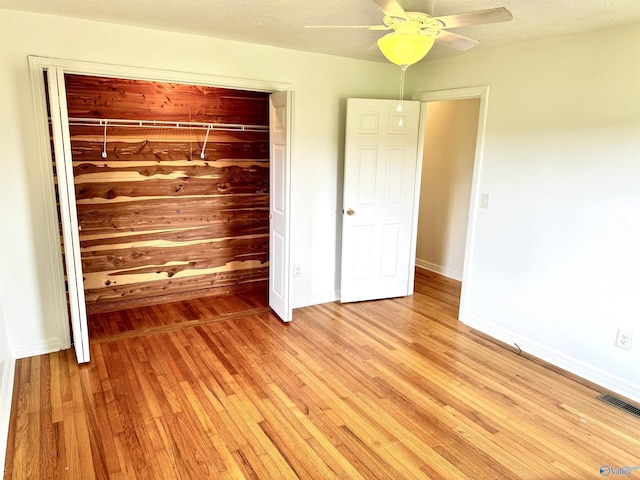 unfurnished bedroom with ceiling fan, visible vents, baseboards, a closet, and light wood-type flooring