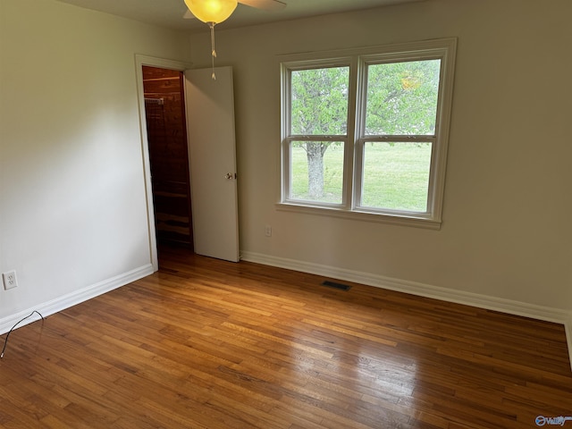 empty room featuring baseboards, visible vents, ceiling fan, and wood-type flooring