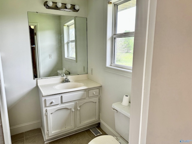 half bath with baseboards, toilet, tile patterned flooring, and vanity
