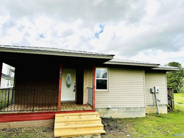 view of front of property featuring metal roof, crawl space, and covered porch