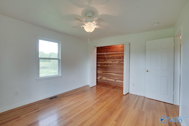 unfurnished bedroom featuring visible vents, a closet, light wood-style flooring, and baseboards