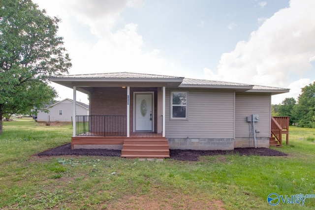 view of front of property featuring covered porch, a front lawn, and metal roof