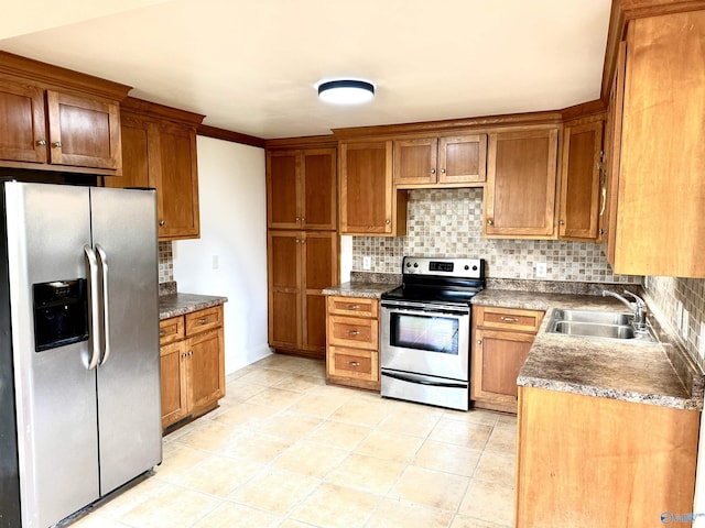 kitchen featuring appliances with stainless steel finishes, decorative backsplash, brown cabinetry, and a sink