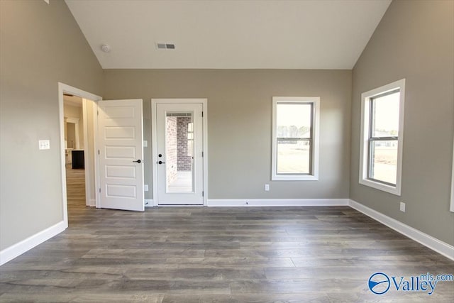 spare room with lofted ceiling and dark hardwood / wood-style floors