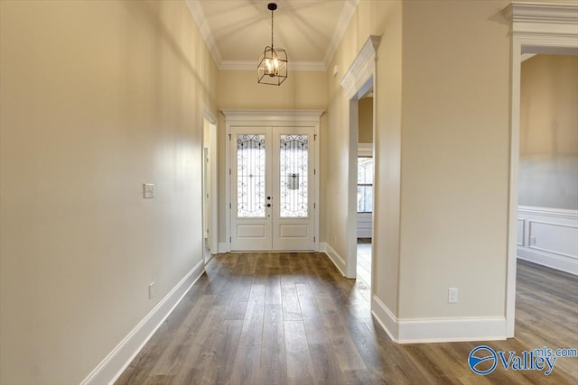 foyer featuring dark hardwood / wood-style floors, an inviting chandelier, crown molding, and french doors