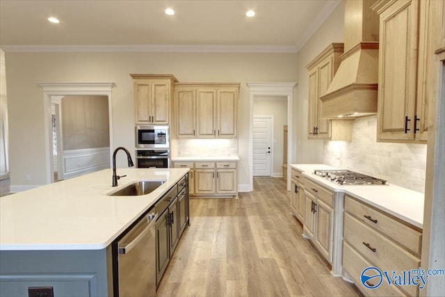 kitchen featuring a kitchen island with sink, light brown cabinets, custom range hood, and ornamental molding