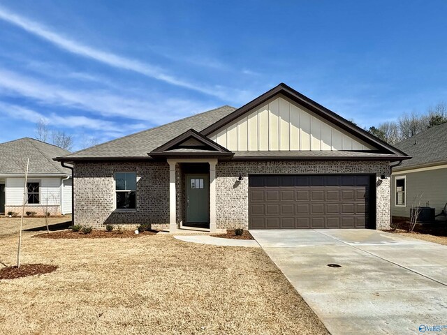 view of front of property with brick siding, driveway, a garage, and board and batten siding