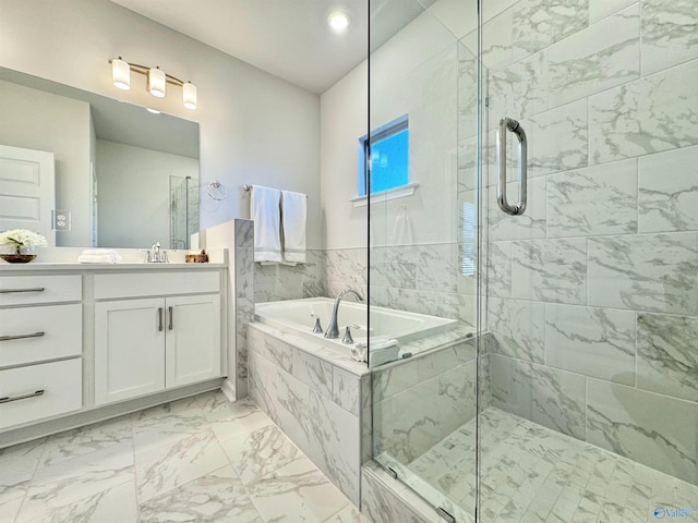 bathroom featuring a stall shower, a garden tub, marble finish floors, and vanity