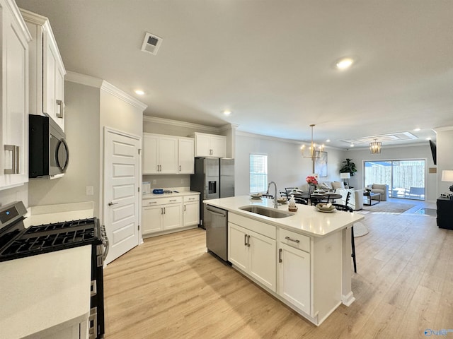 kitchen featuring appliances with stainless steel finishes, a sink, crown molding, open floor plan, and recessed lighting