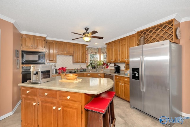 kitchen featuring black appliances, ceiling fan, a center island, a kitchen bar, and backsplash