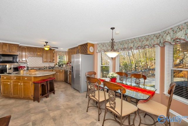 kitchen with tasteful backsplash, light tile patterned floors, ceiling fan, stainless steel appliances, and pendant lighting