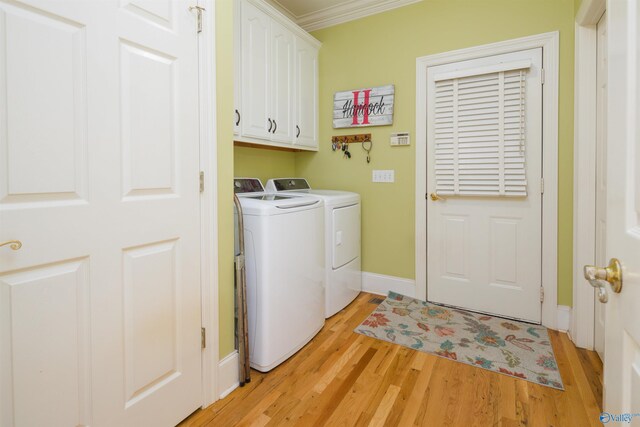 laundry area with cabinets, light hardwood / wood-style flooring, washer and clothes dryer, and crown molding