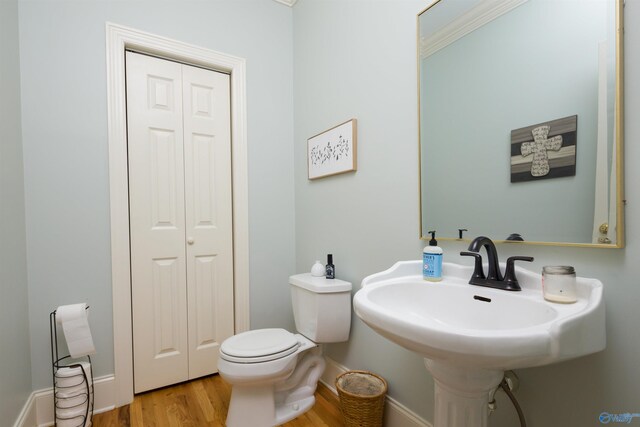 bathroom featuring sink, toilet, wood-type flooring, and crown molding