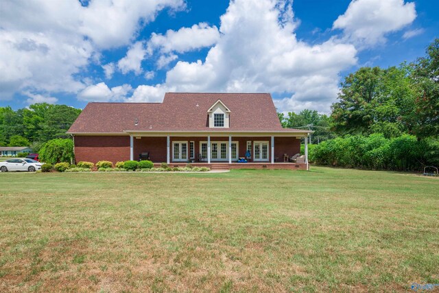 new england style home with covered porch and a front lawn