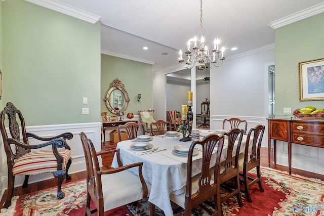 dining space featuring an inviting chandelier, ornamental molding, and hardwood / wood-style flooring