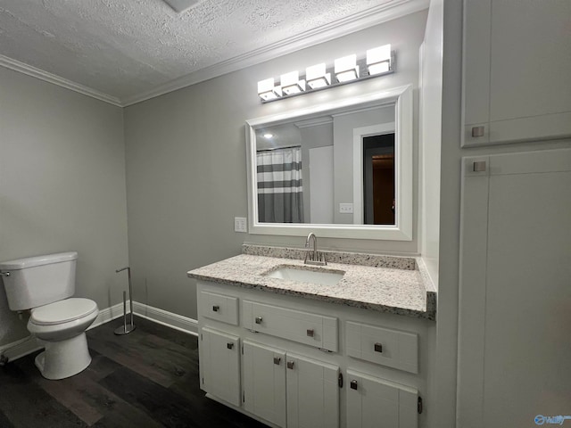 bathroom with a textured ceiling, hardwood / wood-style flooring, toilet, ornamental molding, and vanity